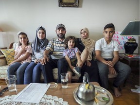 Father Ziad Alrayes and mother Eman Shelh with sons Ziad Jr., right, and Yousef and daughters Abeer and Mariam, left, are refugees from Syria in their home in Notre-Dame-de-Grace.