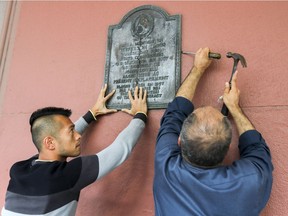 Workers remove a plaque from the side of the Bay commemorating a 1867 visit by Jefferson Davis.