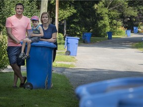 Martin Provost and Simone Clamann with their son, Lennox, in front of their home in Terrasse-Vaudreuil. They were fined $271 by the town for leaving out a rolling bin one day after the regular pickup day.