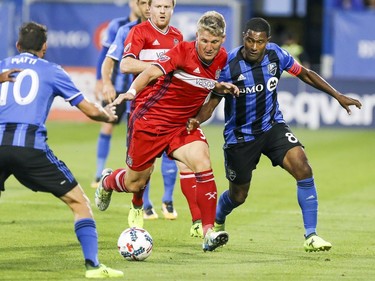 Chicago Fire's Bastian Schweinsteiger, centre, tries to work the ball between Montreal Impact's Patrice Bernier, right, and Ignacio Piatti during second half of MLS action in Montreal on Wednesday August 16, 2017.