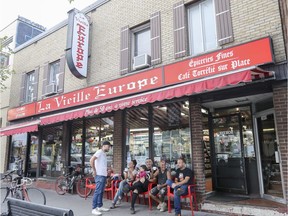 Pedestrians catch a rest on the red chairs set outside the Vieille Europe shop on St-Laurent Blvd. on Friday, Aug. 18. The shop has been issued two $475 tickets by the city for having an illegal terrasse.