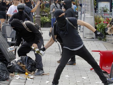 Counter-protesters throw wine bottles at the police during protest against the far-right group La Meute on Sunday, Aug. 20 in Quebec City.