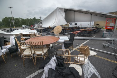 Tables and chairs remain after a severe windstorm ripped apart the large tent set up for this year's Strangers in the Night gala at the Fairview Pointe-Claire parking lot in the West Island of Montreal on Aug. 22, 2017.