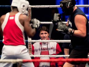 Prime Minister Justin Trudeau coaches Ali Lestor, left, as Lestor fights Pascal Lépine during a charity boxing match benefiting École de la relève on Wednesday.