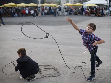 Eleven-year-old Hubert Turenne (R) and his eight-year-old brother Eduard try their hand in roping steer at the rodeo in the Old Port of Montreal, Aug. 24, 2017.