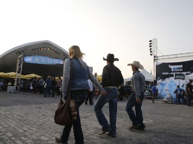 A couple of contestants walk around at the rodeo in the Old Port of Montreal, Aug. 24, 2017.