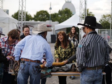 Lucie Bellemare from the South Shore laughs as she watches a demonstration on gear for rodeo contestants in the Old Port of Montreal, Aug. 24, 2017.