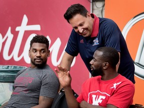 Montreal Alouettes life coach Lorenzo DellaForesta speaks with Michael Carter, right, as Tyrell Sutton looks on, before the start of pregame activities during CFL action at Molson Stadium in Montreal on Thursday August 24, 2017.