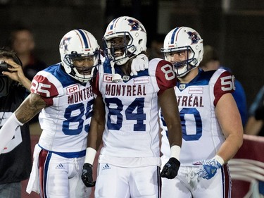 Montreal Alouettes wide receiver B.J. Cunningham, (left to right), Montreal Alouettes wide receiver George Johnson and Montreal Alouettes offensive lineman Matt Vonk celebrate scoring a touchdown against the Winnipeg Blue Bombers during CFL action at Molson Stadium in Montreal on Thursday August 24, 2017.