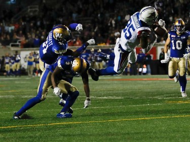 Montreal Alouettes wide receiver B.J. Cunningham scores a touchdown in overtime as Winnipeg Blue Bombers defensive back Kevin Fogg and Winnipeg Blue Bombers defensive back Maurice Leggett collide during CFL action at Molson Stadium in Montreal on Thursday August 24, 2017.