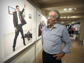 Burhan Ozbilici stands in front of his photograph of the assassination of the Russian ambassador to Turkey, which won the World Press Photo award for photo of the year, at the World Press exhibit in Montreal on Tuesday, Aug. 29, 2017.