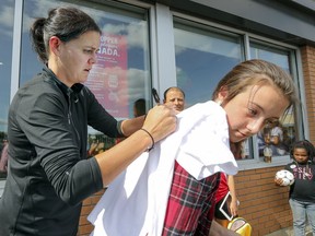 Canadian women's soccer team star Christine Sinclair autographs a T-shirt for Brianna Odell during an initiative by A&W to raise money for multiple sclerosis research in Dollard-des-Ormeaux last Thursday.