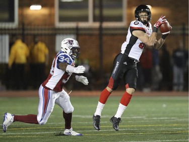 Ottawa Redblacks Greg Ellingson catches a pass in front of Montreal Alouettes Kyries Hebert during second half of Canadian Football League game in Montreal, Thursday August 31, 2017.