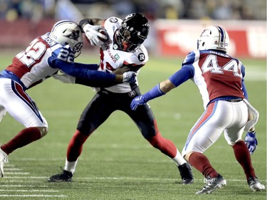 Ottawa Redblacks Dominique Rhymes is tackled by Montreal Alouettes Greg Henderson, left and Branden Dozier during second half of Canadian Football League game in Montreal, Thursday August 31, 2017.