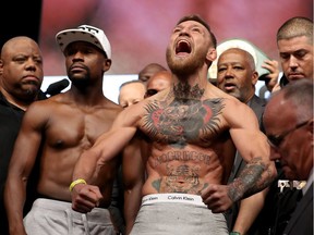 UFC lightweight champion Conor McGregor (R) screams after the face off with Floyd Mayweather Jr. during their official weigh-in at T-Mobile Arena on August 25, 2017 in Las Vegas, Nevada. The two will meet in a super welterweight boxing match at T-Mobile Arena on August 26.  (Photo by Christian Petersen/Getty Images)