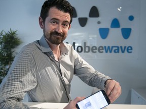 Samuel Mulligan of Mobeewave is seen with cell phone displaying company's app, Tuesday, Aug. 1, 2017.