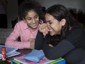 Sisters Saja, left, and Raniah Al Mahamid share a laugh while they express varying opinions about returning to school. Saja wants to be a doctor while Raniah would like to be a journalist.