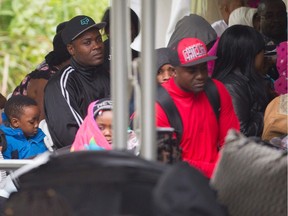 Refugees wait to be processed by the Royal Canadian Mounted Police after crossing the Canada/U.S. border near Hemmingford on Aug. 6, 2017. In recent days, the number of people illegally crossing the border has grown into the hundreds.