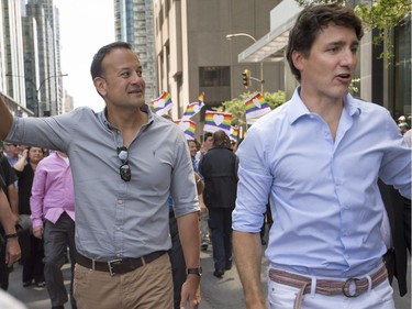 Leo Varadkar, Taoiseach of Ireland left, Canadian Prime Minister Justin Trudeau middle, and  Montreal Mayor Denis Coderre right, walk along Boulevard René-Lévesque during the Pride parade in Montreal on Sunday August 20, 2017.