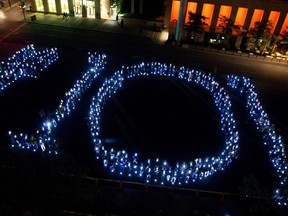 In 2013, 400 people hold candles that form the shape of 101, in reference to Bill 101, as they protest against the use of English in Montreal.
