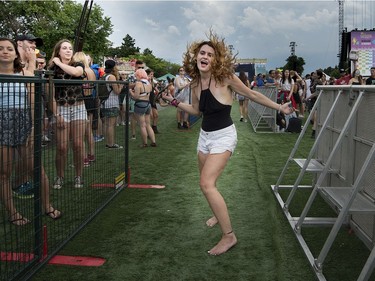 A music lover dances in the walkway during the Osheaga Music and Arts Festival at Parc Jean Drapeau in Montreal on Friday, August 4, 2017.