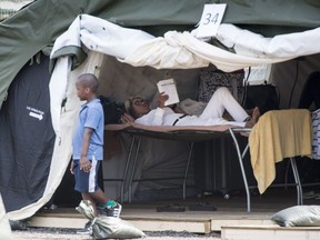 Asylum seekers relax in a temporary camp, Tuesday, August 15, 2017 near Saint-Bernard-de-Lacolle, Que. The camp was set up to cope with the crush of asylum seekers crossing into Canada from the United States. THE CANADIAN PRESS/Paul Chiasson