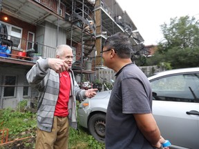 Building owner David Xu and neighbour Serge Lévesque talk after a fire that broke out in the building in the early hours of Aug. 31, 2017. A baby who was in the burning apartment was rescued by Montreal police.