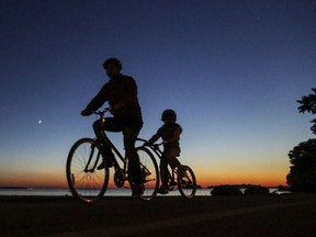 MONTREAL, QUE.: OCTOBER 4, 2016 -- A man and his daughter cycle on the bike path next to Lac St-Louis at dusk in Lachine Tuesday October 4, 2016.  (John Mahoney / MONTREAL GAZETTE)