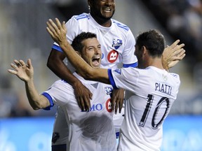 Montreal Impact's Blerim Dzemaili, middle, celebrates with Ignacio Patti, right, and Michael Salazar after scoring a goal during the second half of an MLS soccer match against the Philadelphia Union on Saturday, Aug. 12, 2017, in Chester, Pa. The Impact won 3-0. (AP Photo/Michael Perez)