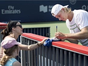 Denis Shapovalov signs a souvenir for Kamilia Caron and her mother, Marie-Élaine Lirette, before a practice session at Jarry Park on Thursday, Aug. 17.