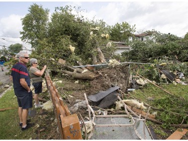 Residents survey the damage from a catagory one tornado, Wednesday, August 23, 2017 in Lachute, Que., northwest of Montreal.