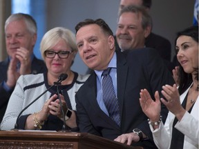 Coalition Avenir Quebec Leader Francois Legault, centre, is applauded at a news conference marking the end of the spring session, Friday, June 16, 2017 at the legislature in Quebec City. Legault is accompanied by members of his caucus.