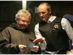 In this image from 2013, Kevin Tierney, left, looks at a Polaroid just taken by actor Colm Feore, right, on the set of the movie Bon cop/Bad Cop. (Richard Arless, Jr. / MONTREAL GAZETTE)