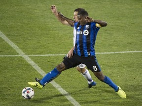 Montreal Impact midfielder Patrice Bernier stretches to kick the ball away from Orlando City SC forward Will Johnson during second half MLS action Saturday, August 5, 2017 in Montreal.