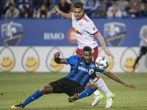 Montreal Impact forward Anthony Jackson-Hamel falls in front of New York Red Bulls midfielder Aaron Long during the second half of MLS action on June 3, 2017, in Montreal.