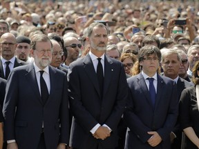 King Felipe of Spain, centre, Prime Minister Mariano Rajoy, left, and Catalonia regional president Carles Puigdemont, right, observe a minute of silence in memory of the terrorist-attack victims in Las Ramblas, Barcelona, Spain, on Friday, Aug. 18, 2017.