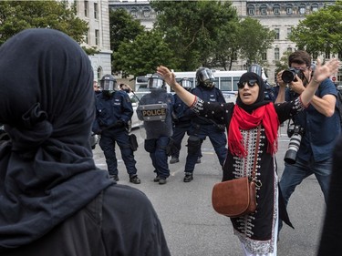 The far-right group La Meute and counter-protesters, organized by a group called Citizen Action Against Discrimination as well as the Ligue anti-fasciste Québec clashed in Quebec City, on Sunday, August 20, 2017. A woman attempted to calm down her fellow protesters as the police kept them moving.