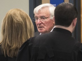 Mike Mergl, centre, talks to lawyers as he arrives for the Laval's municipal corruption case at tJuly 11, 2017.