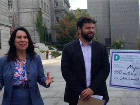 Projet Montréal leader Valérie Plante and candidate Éric Alan Caldwell stand in front of a novelty cheque to show that the mayor is ready to spend public money without consulting Montrealers.