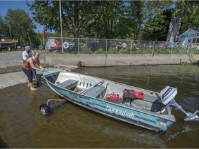 Rick Cartmel and his daughter Laura put their boat into the water recently at the Canadian Forces Sailing Association base in Dorval.
