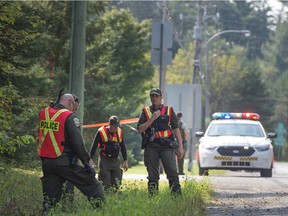 Sûreté du Québec officers search the area where a white pickup truck was found parked overnight in a park in Lachute Sept. 15, 2017, after an Amber Alert for a 6-year-old abducted from St-Eustache.