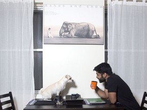Shanil Perera and his dog Bailey under his favourite print in the dining area of his apartment in Old Montreal.