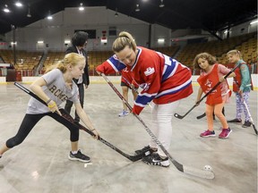 Les Canadiennes de Montréal's Karell Emard is challenged for the ball by Notre Dame des Sept Douleurs school student Rosalie Dubreuin during ball hockey game at the Verdun Auditorium in Montreal Monday September 18, 2017 following announcement that the Auditorium would become Les Canadiennes' permanent training facility beginning in 2019.