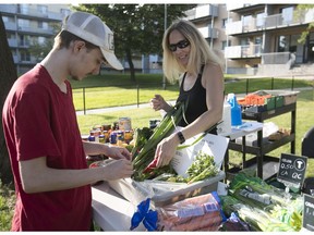 Kevin Lussier, left, buys vegetables from Josée Perron at the Marché communautaire Duff-Court on Thursday September 14, 2017.