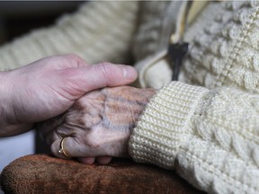 A picture taken on March 18, 2011 shows a woman suffering from Alzheimer's disease holding the hand of a relative in a retirement house in Angervilliers, eastern France. While progress is made in research, the disease remains without cure.