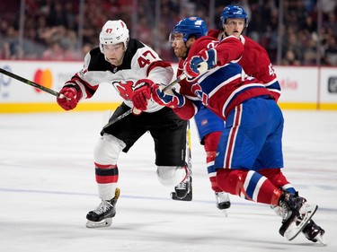 Montreal Canadiens defenceman Zach Redmond holds back New Jersey Devils centre John Quenneville during pre-season NHL action at the Bell Centre in Montreal on Thursday September 21, 2017.