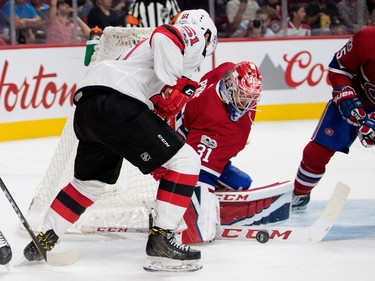 Montreal Canadiens goalie Carey Price gets his stick on the puck as New Jersey Devils centre Brandon Gignac looks for a rebound during pre-season NHL action at the Bell Centre in Montreal on Thursday September 21, 2017.