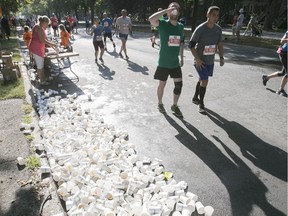 Empty water cups litter the street near Lafontaine Park during the Montreal half-marathon on Sunday September 24, 2017.