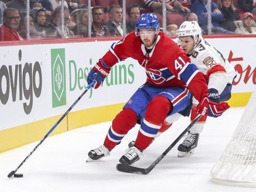 Canadiens' Paul Byron holds off Florida Panthers' Evgenii Dadonov as he carries the puck behind the Panthers' net in Montreal  on Friday, Sept. 29, 2017.