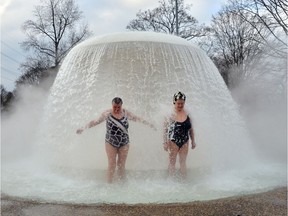 Two women stand under a fountain in the so-called "Sonnenbad" (Sun bath) swimming pool at temperatures just below 0 degrees Celsius during the opening of the pool for the new season Karlsruhe, southern Germany on February 22, 2013. Temperature changes from hot to cold are still thought by some to bring health benefits.